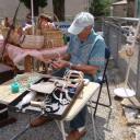 Een mandenmaker vlecht een mandje op het dorpsfeest in Saint Julien du Gua